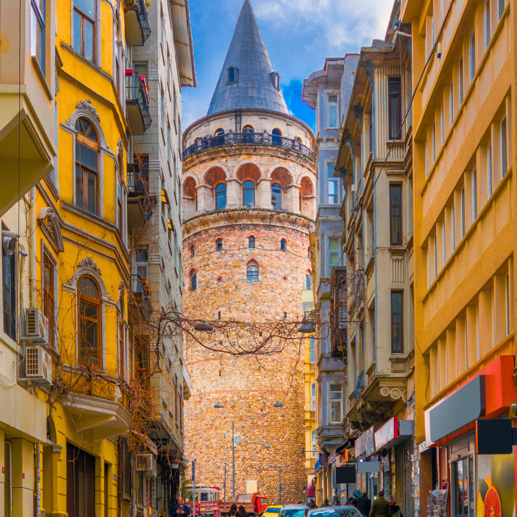 View of the Galata Tower in Istanbul surrounded by historic buildings and narrow street.